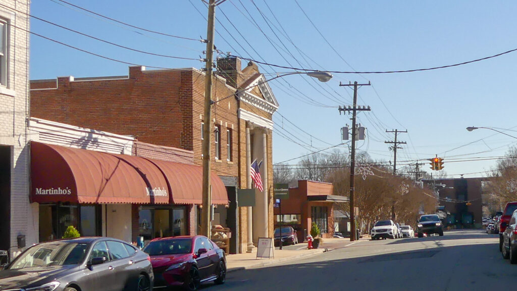 Downtown Mebane with the view focusing on Martinho's deli and bakery storefront with cars lining the roads